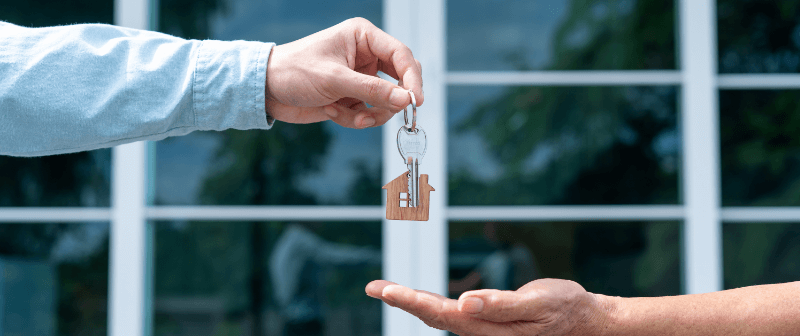 a man handing over the keys to his home to a seller